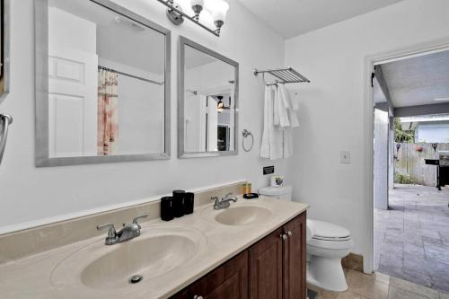 een witte badkamer met een wastafel en een toilet bij Waterfront Hidden Gem 4BR Heated Pool & Game Room in Fort Lauderdale