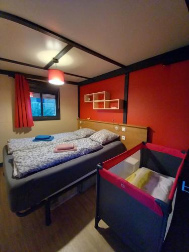 une chambre avec un lit et un mur rouge dans l'établissement Bruse & Costa à la montagne, à Chorges