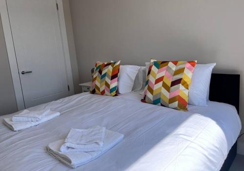 a white bed with towels and pillows on it at Margate Seaside Haven With 2 Terraces Sleeps 6 in Kent