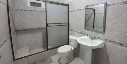 a bathroom with a toilet and a sink at Albo home in Guayaquil