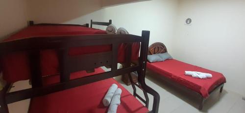 2 literas con sábanas rojas en una habitación en Albo home, en Guayaquil