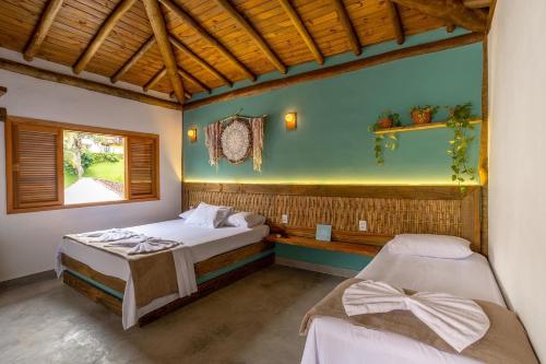 Un dormitorio con dos camas y una ventana. en Suítes Casa Maembippe, en Ilhabela