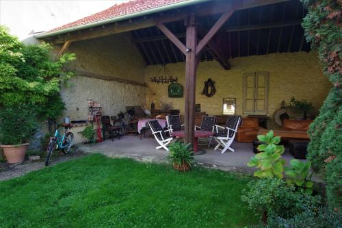 a patio of a house with chairs and a table at L ESCALE EN BEAUCE in Maisons