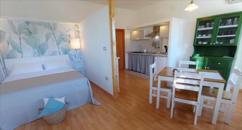 um quarto com uma cama, uma mesa e uma cozinha em Il Portico Rosa em Cuglieri