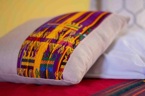 a colorful pillow sitting on top of a bed at Casa Esperanza in Panajachel