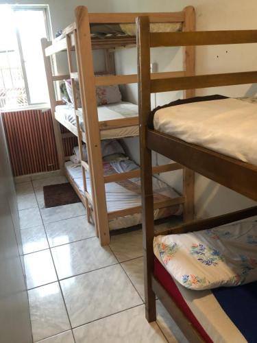 een kamer met een stapelbed en een tegelvloer bij Hostel Celine in São Bernardo do Campo