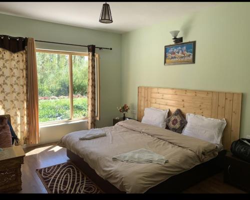 um quarto com uma cama grande e uma janela em Leh Stumpa em Leh