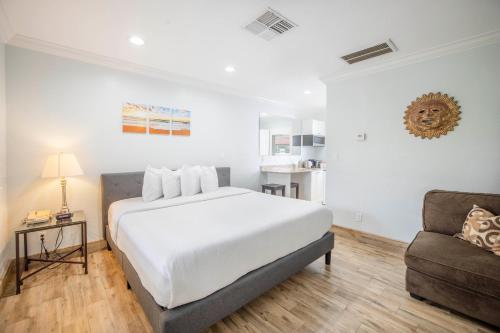 a white bedroom with a bed and a couch at Hotel SOL in St Pete Beach