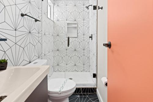 uma casa de banho com um WC branco e um chuveiro em 5BR Beach Block Orange Loop Steps from Boardwalk em Atlantic City