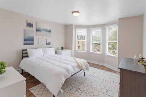 um quarto branco com uma grande cama branca e janelas em 5BR Beach Block Orange Loop Steps from Boardwalk em Atlantic City