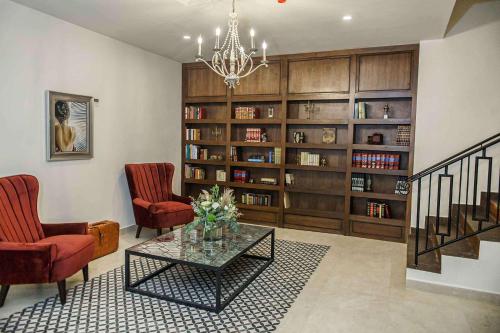 Casa Maria Boutique Hotel في سان كارلوس: غرفة معيشة مع كرسيين وطاولة ورف كتاب