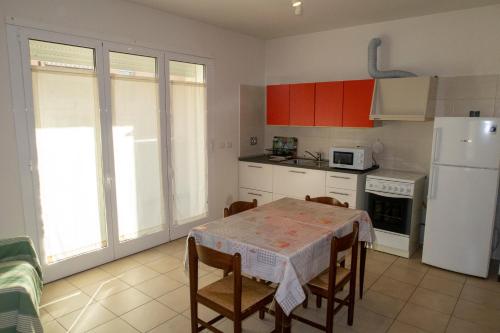 een keuken met een tafel en een witte koelkast bij Bilocale Esperanto in Pianoro