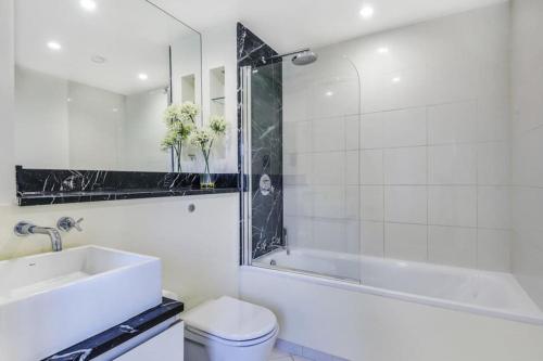 a bathroom with a sink and a tub and a toilet at Tower Bridge Lux-Penthouse in London