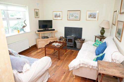 a living room with two white couches and a tv at The River House in Slane
