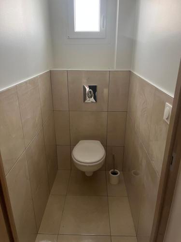 a small bathroom with a toilet and a window at Charmant pavillon de 70 m2 in La Charité-sur-Loire