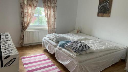 1 dormitorio con cama blanca y ventana en Manus Ferienwohnung, en Brevik