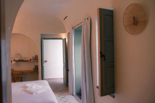 a bedroom with a bed and an open door at Riad Lalla Mimouna in Marrakech