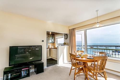a living room with a table and a television at 8 Dolphin Court in Brixham