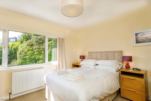 a bedroom with a bed and a large window at 8 Dolphin Court in Brixham