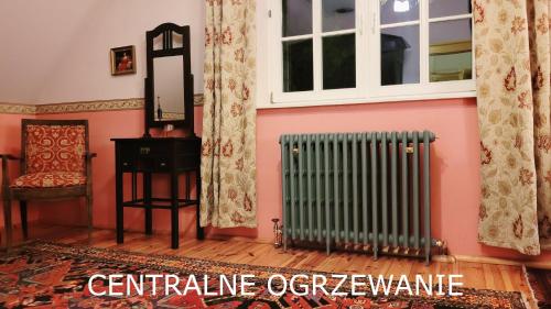 a room with pink walls and a radiator and a mirror at Willa Reglówka Stylowy dom Pachnący ogród in Wola Krakowiańska