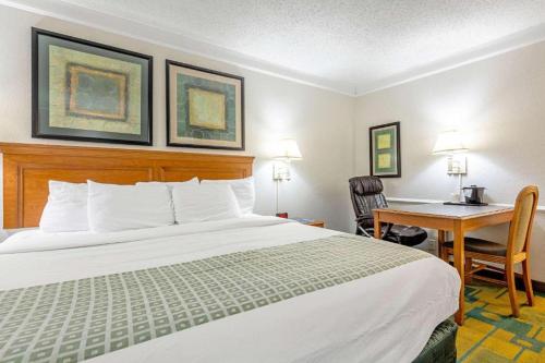 a hotel room with a bed and a desk at Rodeway Inn Huntsville West in Huntsville