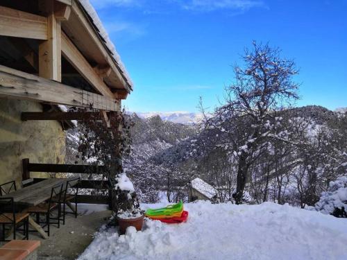 a snow covered porch of a cabin with a table and snow at Gîte de la Chabespa, belle vue, au calme in Sigottier