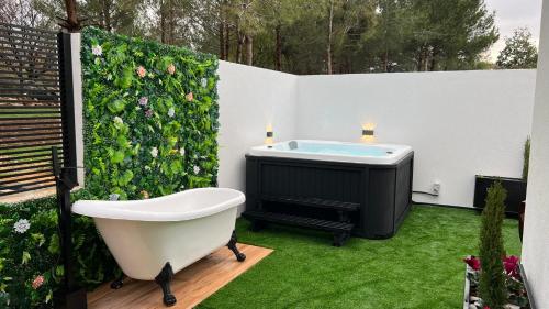 Un baño con bañera y un seto verde. en Dian’s suits, en Gita