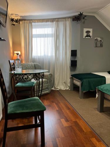 ein Wohnzimmer mit einem Bett, einem Tisch und einem Sofa in der Unterkunft Кузня міні-готель in Mateyevtsy