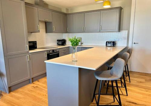 a kitchen with a counter and stools in it at Margate Beach Front Apt With Sea Views Sleeps 6 in Kent