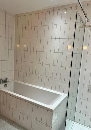 a bathroom with a tub and a glass shower at Margate Beach Front Apt With Sea Views Sleeps 6 in Kent