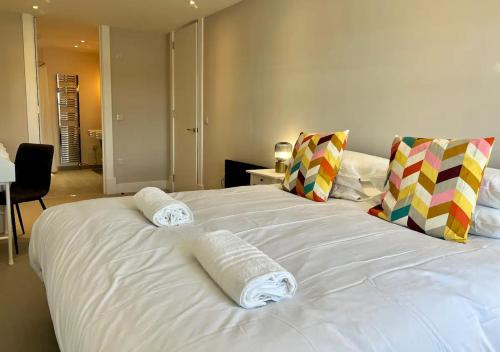 a large white bed with two towels on it at Margate Beach Front Apt With Sea Views Sleeps 6 in Kent