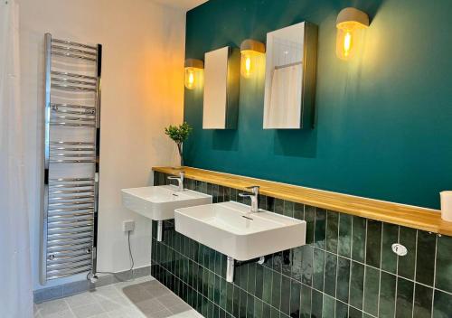 ein Badezimmer mit zwei Waschbecken und einer grünen Wand in der Unterkunft Margate Beach Front Apt With Sea Views Sleeps 6 in Kent