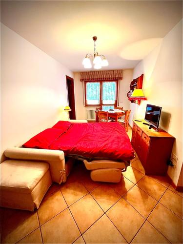 a bedroom with a red bed and a desk at Stella Alpina in Tarvisio
