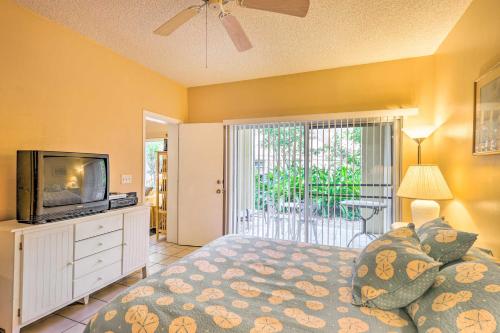 a bedroom with a bed and a tv and a window at Ft Lauderdale Area Condo - Walk to Beach and Shops! in Fort Lauderdale