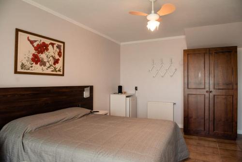 um quarto com uma cama e uma ventoinha de tecto em Hotel Vila Verde em Nova Petrópolis