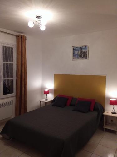 ラ・コティニエールにあるiledoのベッドルーム1室(赤い枕の大きな黒いベッド1台付)