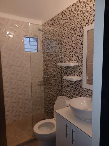een badkamer met een toilet, een wastafel en een douche bij Doña Mayra Aparta Hotel in Las Terrenas