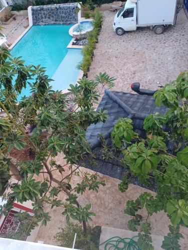 a swimming pool with a car parked next to it at Doña Mayra Aparta Hotel in Las Terrenas