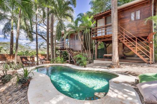uma casa com piscina em frente a uma casa em The Beach Bungalows - Yoga and Surf House - Adults Only em Tamarindo