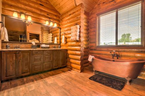 a bathroom with a tub in a log cabin at Dreamy Kanab Cabin with Hot Tub and Panoramic Views! in Kanab