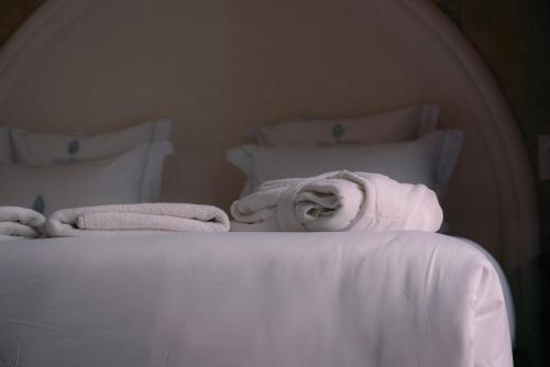 a white bed with white sheets and towels on it at Riad Lalla Mimouna in Marrakech