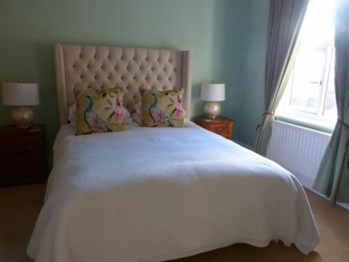 um quarto com uma cama branca, 2 candeeiros e uma janela em Inglewood em Chorley