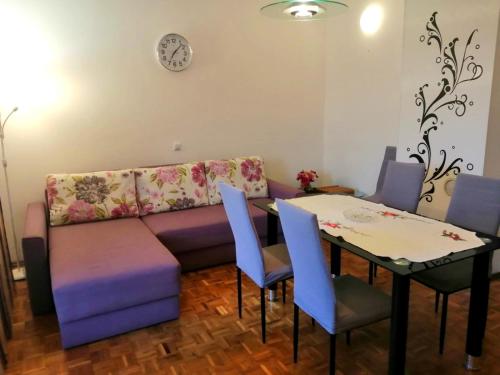 a living room with a couch and a table with chairs at Apartments Kočović in Peroj