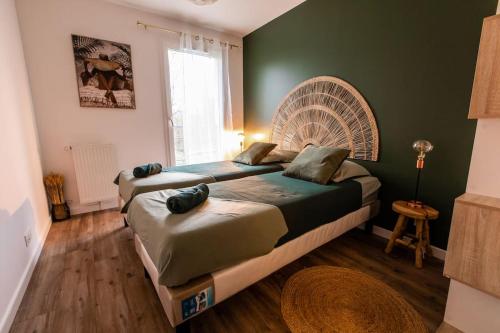 1 Schlafzimmer mit 2 Betten und einem großen Fenster in der Unterkunft Forest Chic : Maison San Marina in Parmain
