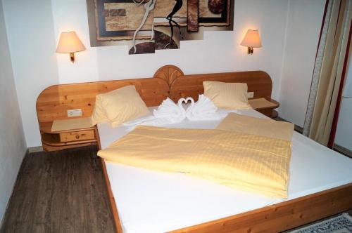 a bedroom with a large white bed with two pillows at Sieglhub Chalets - Appartements - Hotel in Flachau