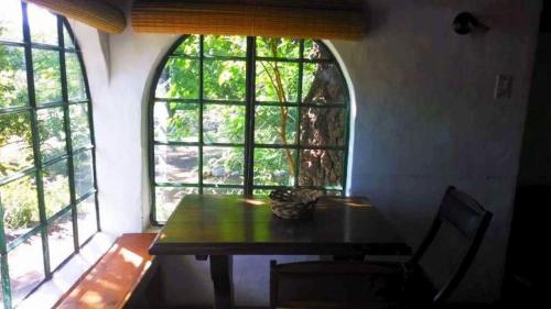 a dining room with a table and two windows at Cabaña Hannah in San Marcos Sierras