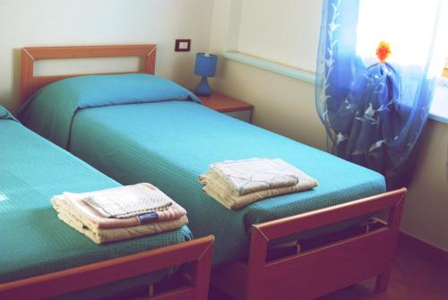 two beds in a bedroom with towels on them at Tanca is Torus in Teulada
