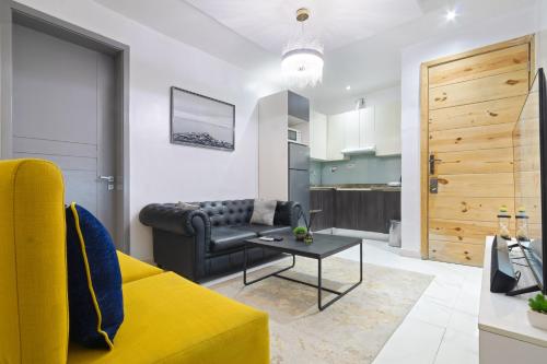 a living room with a yellow couch and a table at Exclusive Upscale 1 Bedroom Apartment in Lekki phase 1 in Lagos