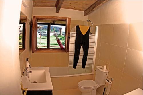 Un baño con lavabo, inodoro y ventana. en Surf House, en Callao Salvaje