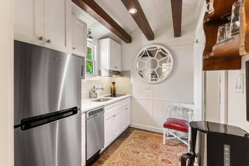 une cuisine avec des armoires blanches et un réfrigérateur en acier inoxydable dans l'établissement Gull Guest Cottage - 757 Ocean Blvd, à Saint Simons
